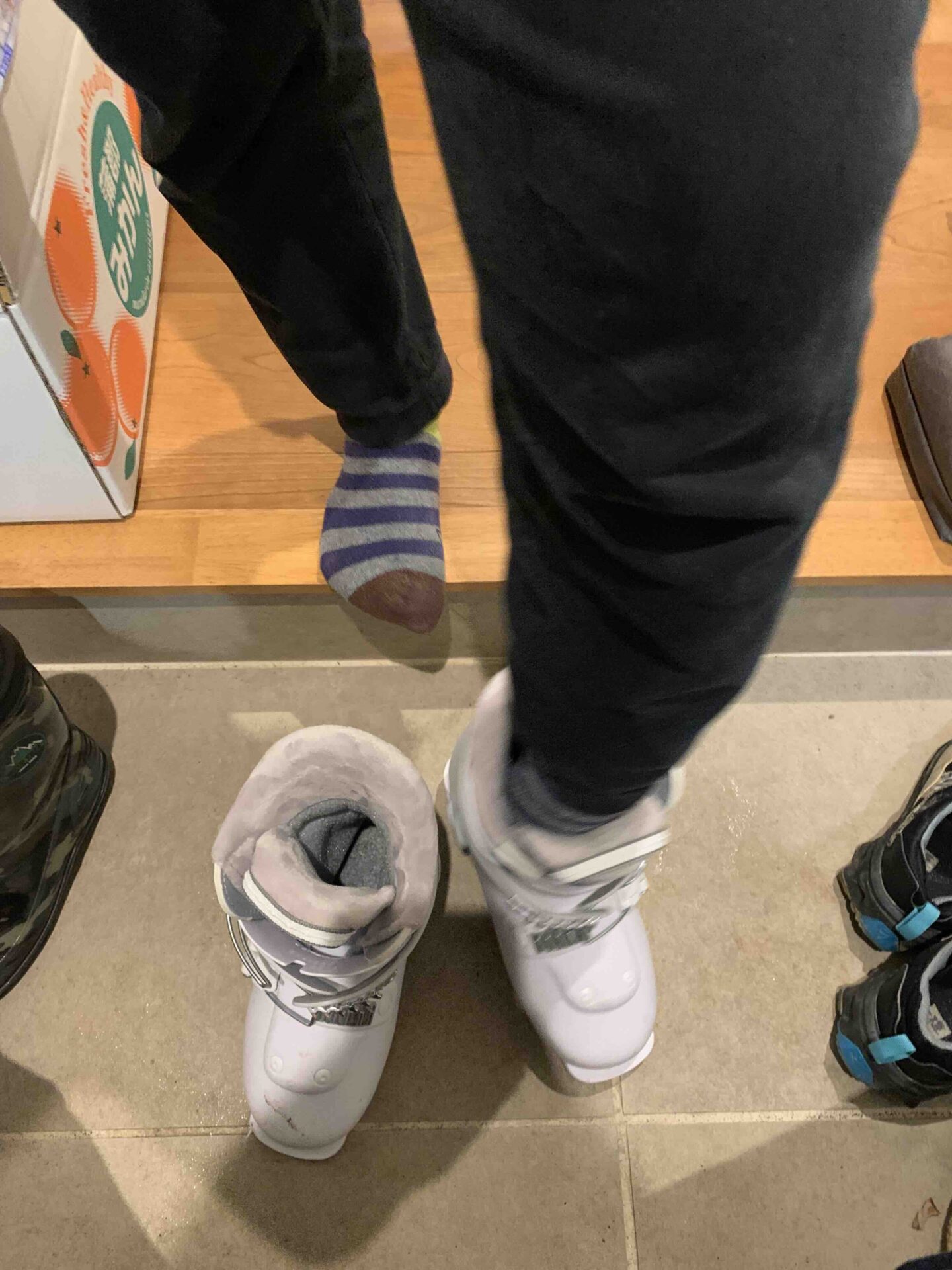 スキーの準備でブーツを履いている子どもたち