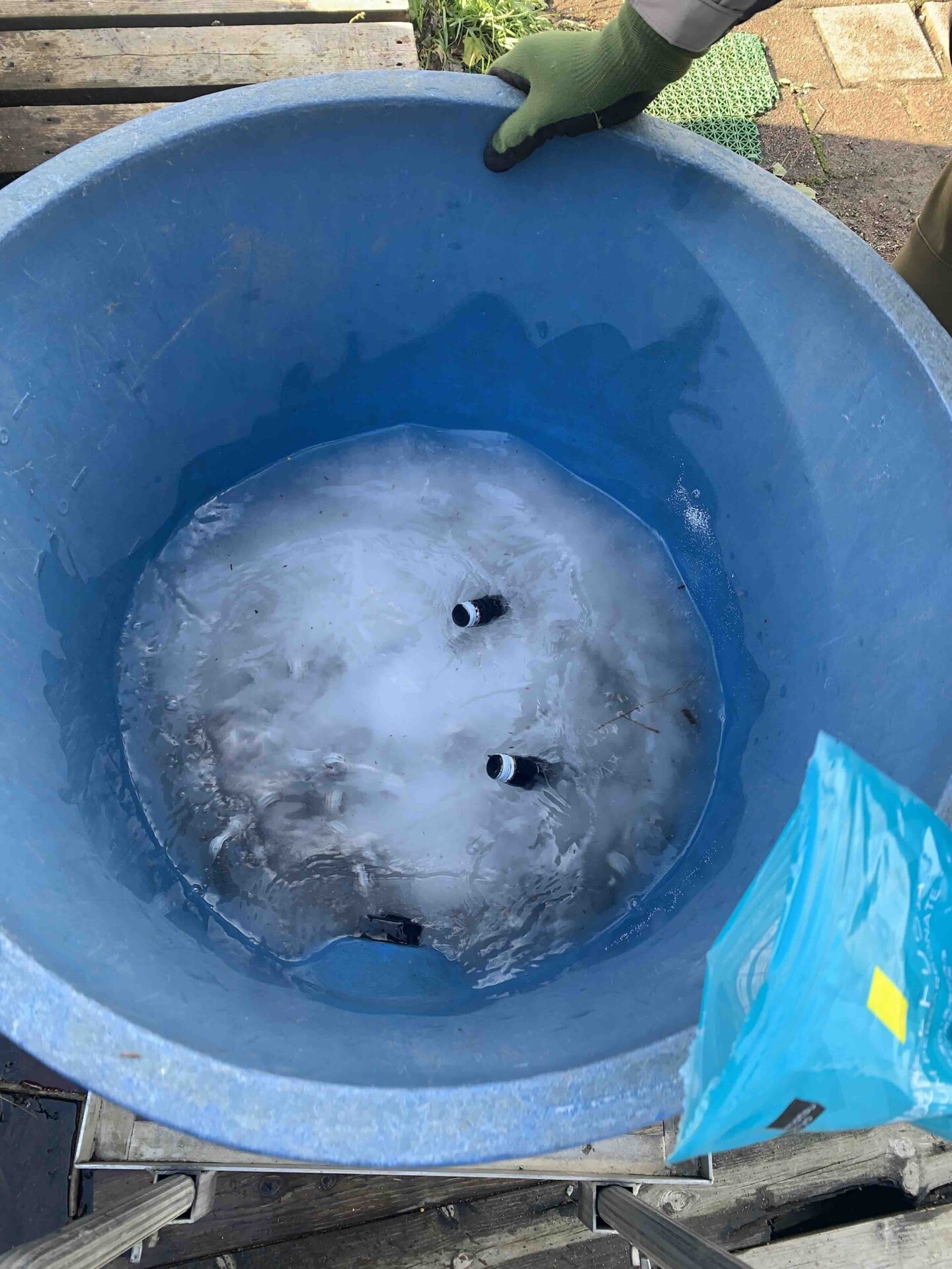 スプリンクラー部品を過炭酸ナトリウムに浸けて掃除している様子